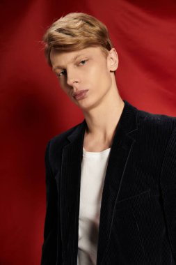 Genç adam, canlı bir arka planda modern erkeklik ve çekicilik sergiliyor..