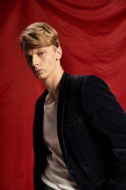 Genç, yakışıklı bir adam kendine güvenen bir duruş sergiliyor, modern erkeklik tarzını sergiliyor..