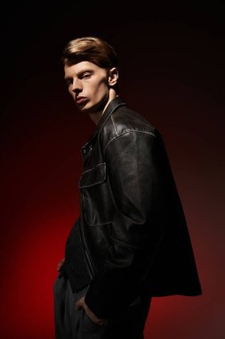 Genç, çekici bir adam kendine güvenerek, dramatik ışıklandırmayla modern tarzı sergiliyor..