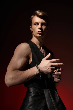 Genç bir adam karanlık bir arka plana karşı modern erkeklik ve güven yayar..