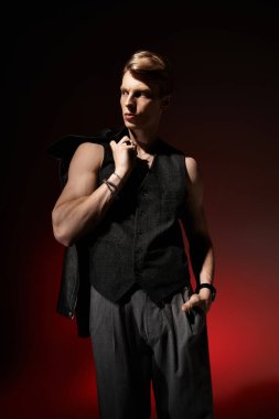 Genç bir adam kendine güvenen bir duruş ve çarpıcı bir kıyafetle cazibesini ve modern tarzını sergiliyor..