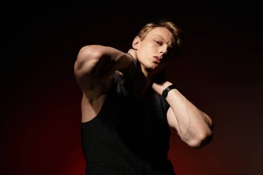 Şık genç adam, sanatsal bir ortamda kendine güvenen bir pozla modern erkeksiliği sergiliyor..