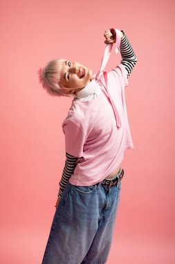 Genç bir kadın neşeli bir elbiseyle ışıldıyor, neşeli bir şekilde poz veriyor..