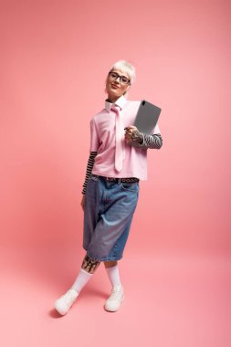 Genç bir kadın elinde bir tablet tutarken kendine güvenini gösterir..