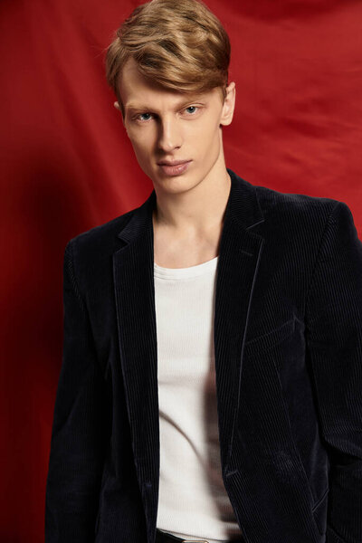 Handsome young man displays confidence in a sleek outfit, showcasing modern masculinity.