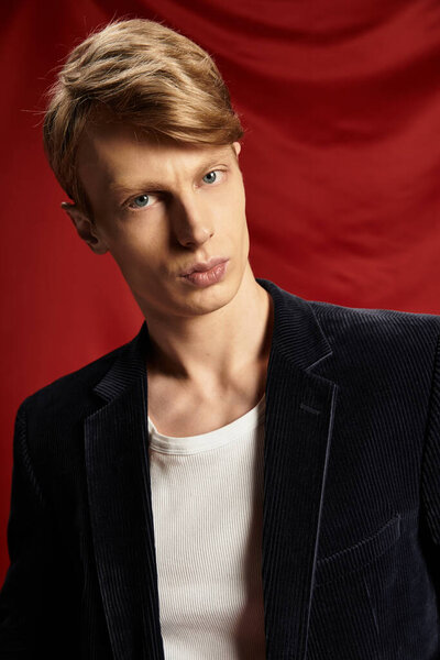 A handsome young man poses confidently, reflecting modern masculinity with charm and elegance.