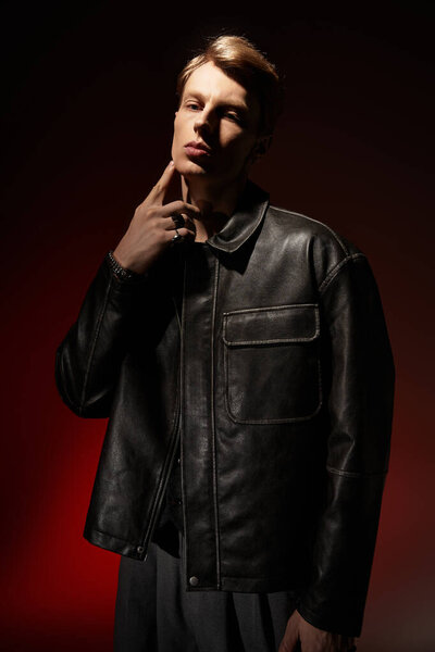 A young man showcases modern masculinity in a stylish black jacket with dramatic lighting.