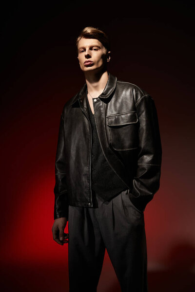 A young, alluring man showcases modern masculinity in a dark setting with captivating lighting.