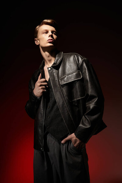 A handsome young man poses confidently in leather clothing, showcasing modern masculinity and style.