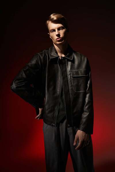 A young man stands confidently in sleek attire, showcasing contemporary masculinity.