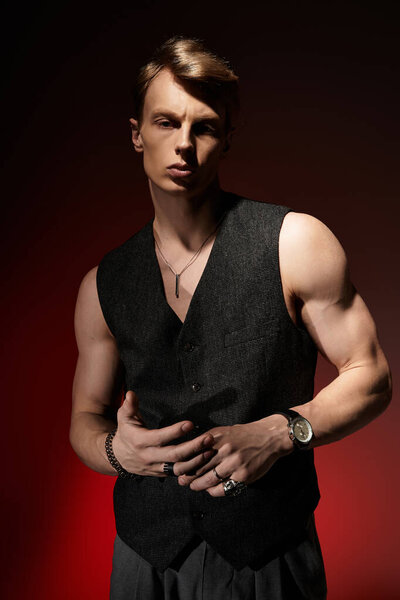 A confident young man displays modern masculinity with a captivating pose against a bold background.