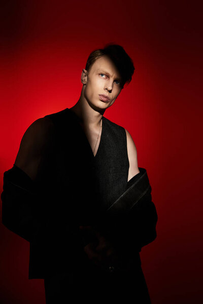 A young and handsome man stands confidently, showcasing modern masculinity under dramatic lighting.