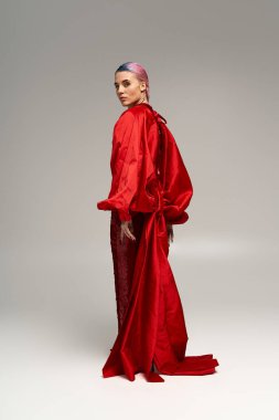 Canlı kırmızı elbiseli genç bir kadın kış şenliklerinde tarzını sergiliyor..