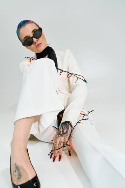 Zarif kış modasında genç bir kadın zarif ışıkların arasında oturuyor..