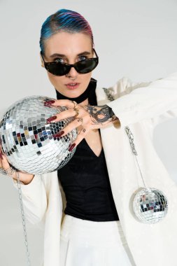 Parlak disko toplarını tutarken güzel, genç bir kadın zarif pozlar veriyor..