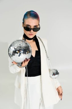 Güzel genç bir kadın, eğlence için disko toplarını tutarak şenlikli bir kış atmosferini kucaklıyor..