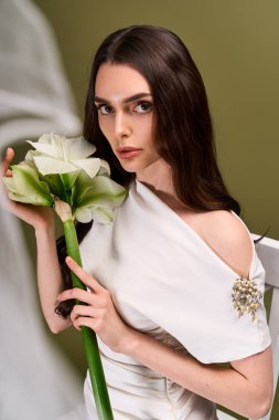 Genç gelin, güzel ve zarafet saçıyor çarpıcı bir çiçekle, neşe ve sevgi saçarak.