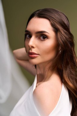 Çekici bir gelin zarif pozlar verir, güzelliğini ve neşesini sakin bir ortamda sergiler..