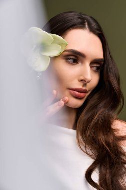 Genç bir gelin, huzurlu bir atmosferde narin bir çiçekle süslenmiş neşe ve zarafet ifade eder..