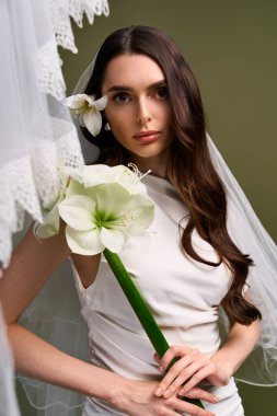 Uzun saçlı ve çiçek buketli genç gelin dingin güzellikte duruyor, neşe ve zarafet saçıyor..