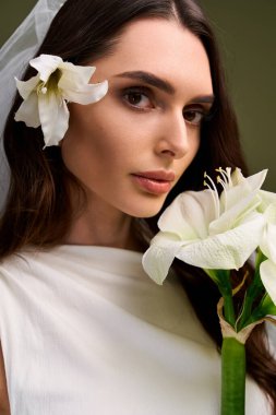 Genç gelin, elinde çiçeklerle, neşe ve mutlulukla parıldıyor..