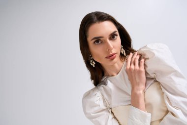 Parlak bir gelin zarif bir pozla güzelliğini ve zarafetini sergiler..