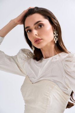 Genç bir gelin zarif poz verir, neşe saçar ve güzel bir gelinlik giyer..