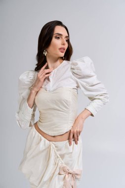 Genç ve güzel gelin, basit bir ortamda zarifçe poz veriyor, neşe ve aşkın somutlaştırıcısı..