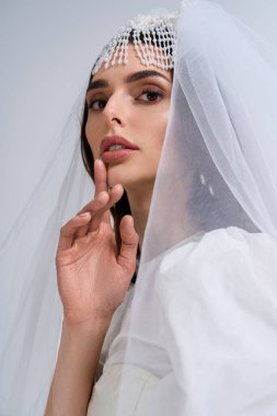 Çekici bir gelin zarifçe poz verir, zarafetle sarılır ve özel gününde mutluluk saçar..