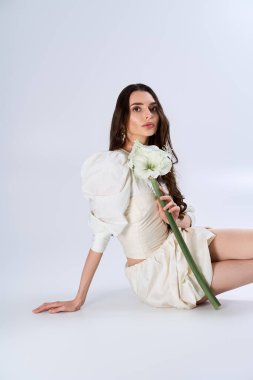 Çekici bir gelin zarif bir şekilde poz verir. Stüdyoda zarafet ve neşe saçar..