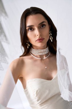 Genç bir gelin huzurlu bir ortamda zarif mücevherlerle güzellik ve zarafet saçar..