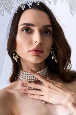 Genç gelin zarafet saçıyor göz kamaştırıcı mücevherler ve neşe dolu narin bir peçeyle..