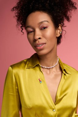 Sarı bluzlu genç bir kadın ışıl ışıl bir gülümseme saçar, neşe saçar.