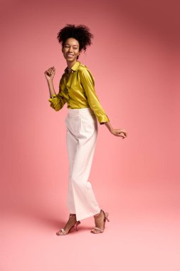 Şık giyinmiş genç bir kadın neşe içinde dans ediyor, sıcacık bir ortamda mutluluk saçıyor..