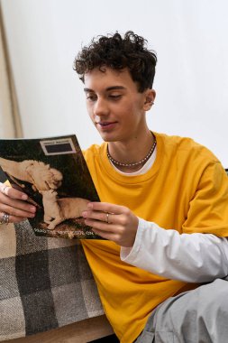 Moda çocuğu rahat bir yaşam alanında dergi okurken rahatlıyor..