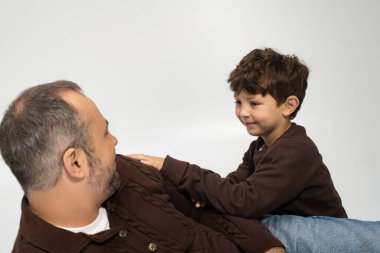 Bir baba ve küçük oğlu sıcak bir tebessümü paylaşırken birlikte güzel vakit geçiriyorlar..