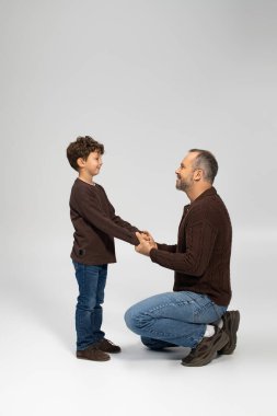 Neşeli bir baba oğluyla birlikte diz çöker ve sıcak bir ortamda özel bağlarını kutlar..