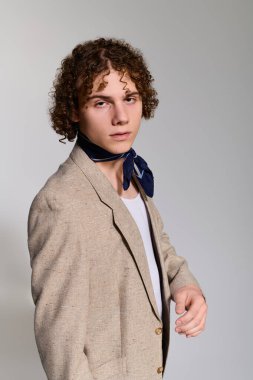 Genç moda meraklısı modern bir stüdyoda şık bir görünüşle poz verirken kendine güven yayıyor..