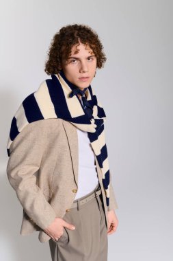 Genç, kendine güvenen bir şekilde modaya uygun bir şekilde poz veriyor. Eşsiz bir doku ve renk karışımı..