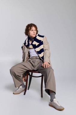 Ergen, kapalı mekanda yaratıcı bir şekilde poz verirken eşsiz moda seçimleri sergiliyor..