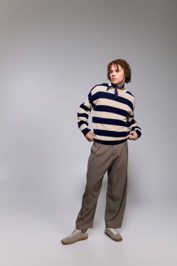 Moda kıyafetli genç, kendine güvenen bir duruş sergiliyor. Kişisel stil ve yetenek sergiliyor..