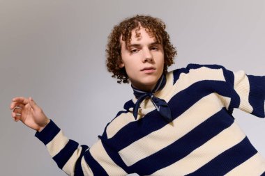 Moda kıyafetli genç, canlı bir arka plana karşı aktif bir poz verdi, gösteriş tarzı..