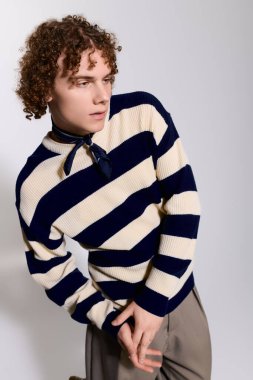 Şık bir genç zarif bir duruş sergiliyor, modern modayı beceri ve özgüvenle vurguluyor..