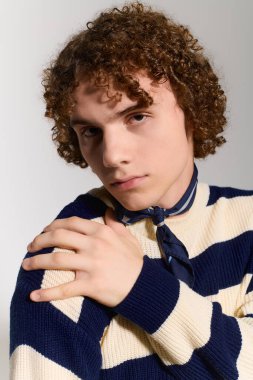 Aktif genç, kendine güvenen bir duruş sergilerken modaya uygun bir kıyafetle benzersiz bir tarz sergiliyor.