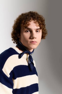 Gençler eşsiz bir stil sergiliyor. Kıvırcık saçlı, şık bir atkısı var. Gençlik enerjisi saçıyor..