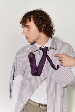 Çekici genç aktif bir şekilde moda kıyafetleriyle poz veriyor, modaya oyuncu bir bakış açısı getiriyor..