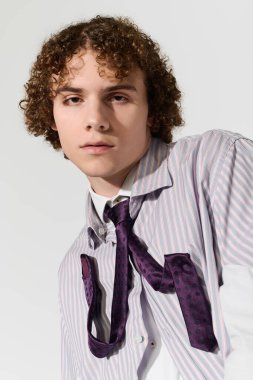 Kıvırcık saçlı ergen kendine güvenen şık bir elbise içinde yaratıcı moda seçimleri sergiliyor..