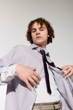 Şık bir genç aktif bir duruş sergiliyor, bireysel stil ve beceri sergiliyor..