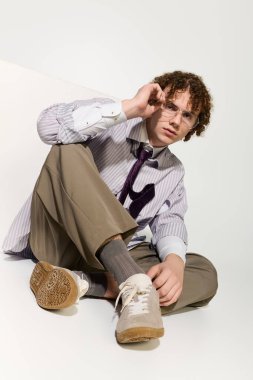 Gençler modaya uygun kıyafetlerle yaratıcı bir tarz sergiliyor. Parlak ve minimal bir yerde rahat bir duruş sergiliyor..