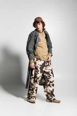 Gençler stüdyoda poz veriyor, moda tarzlarının ve dokuların eşsiz bir karışımını sergiliyorlar..